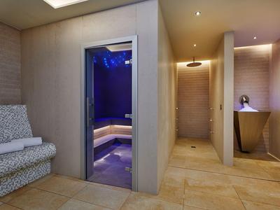 Moderne spa met een saunaruimte en zachte zitplaatsen in een stijlvolle inrichting.