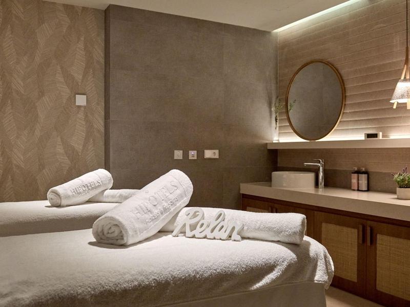 Rustige wellnessruimte met massagetafels, handdoeken en warm licht.