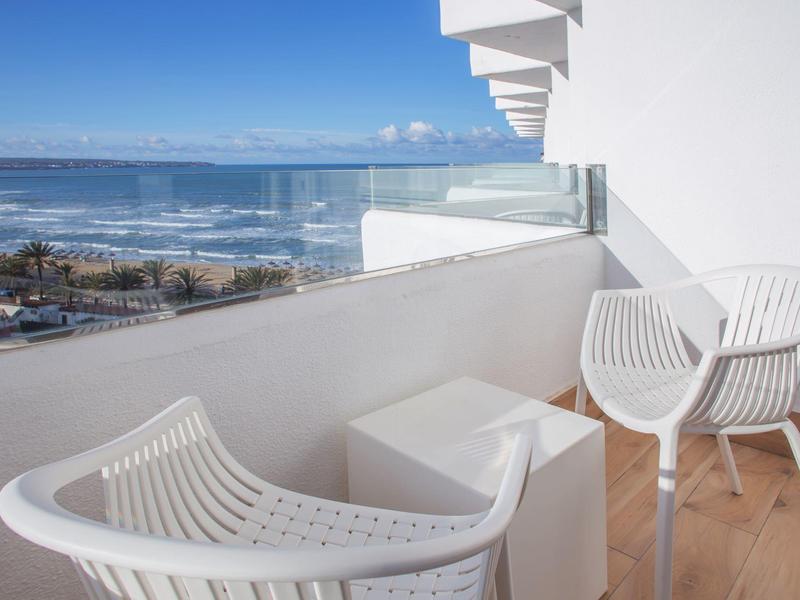 Terras met witte stoelen en uitzicht op zee op een zonnige dag