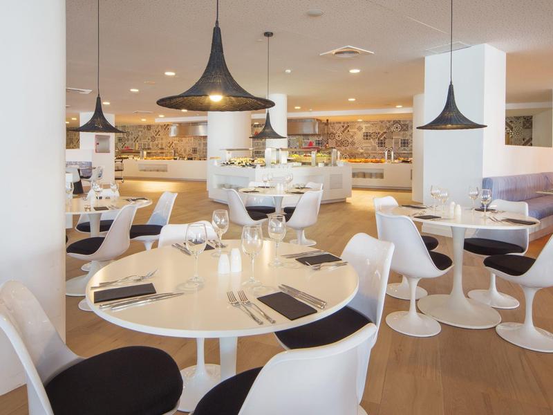 Modern ingerichte hotelrestaurantruimte met ronde tafels en stijlvolle stoelen.