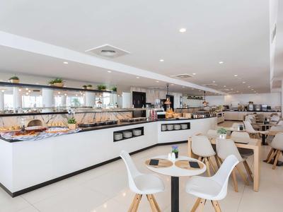 Modern, licht hotelrestaurant met buffetgedeelte en stijlvolle zitplaatsen.