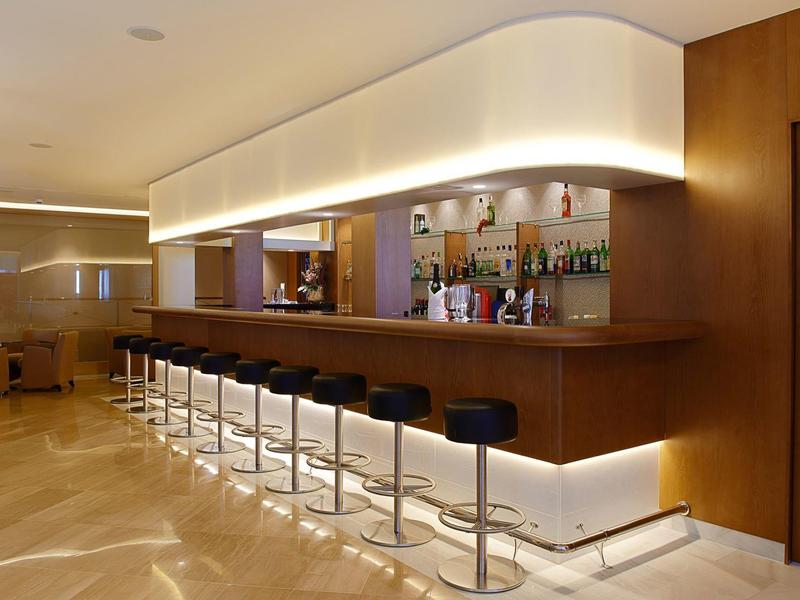 Moderne hotelbar met krukken en indirecte verlichting.