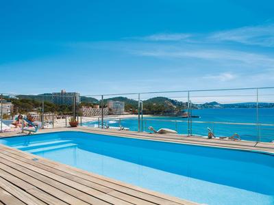 Zwembad op een terras met uitzicht op zee onder een heldere blauwe lucht