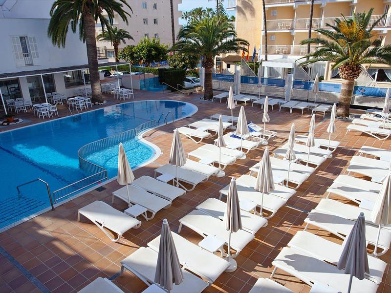 Nowoczesny basen na zewnątrz z leżakami i zamkniętymi parasolami w hotelu.