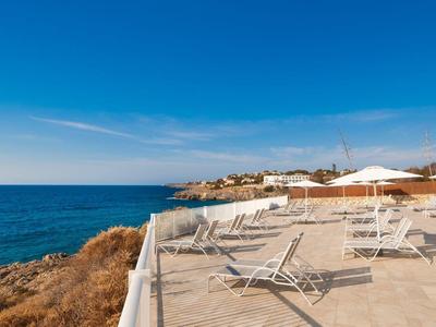 Puste leżaki i parasole nad morzem w słoneczny dzień.