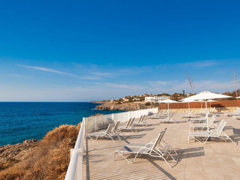 Puste leżaki i parasole nad morzem w słoneczny dzień.