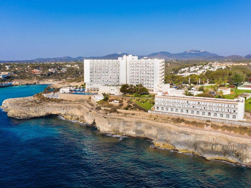 Nowoczesny hotel na klifie z widokiem na niebieskie morze i czyste niebo.