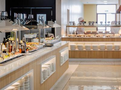 Licht buffet met diverse voedingsmiddelen en dranken in een moderne eetruimte.