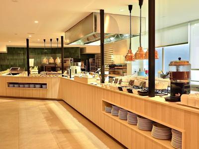 Modern breakfast area with buffet and neatly arranged dishes.