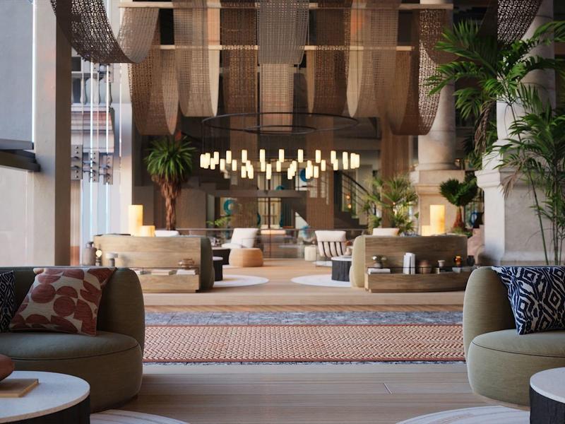 Nowoczesna przestrzeń lounge hotelu z wygodnymi fotelami i ciepłym światłem ambientowym.