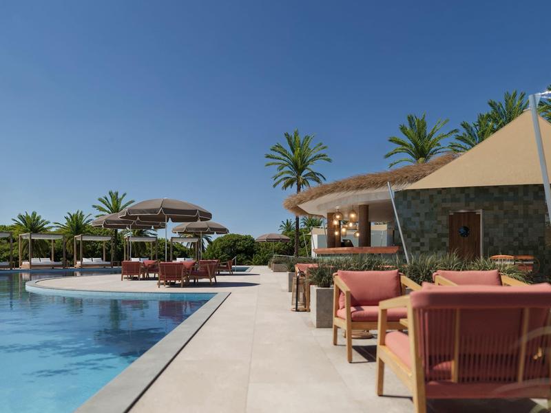 Nowoczesny basen z fotelami lounge i palmami pod jasnym niebem.