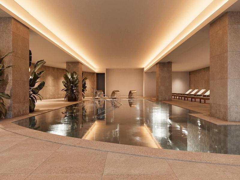 Nowoczesny basen kryty z prostą architekturą i leżakami przy basenie.