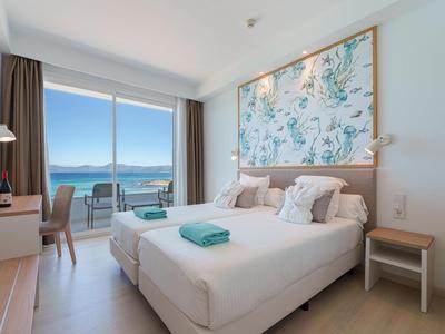 Modernes Hotelzimmer mit zwei Betten, großem Fenster und Meerblick.