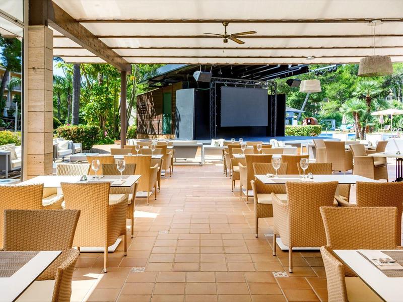 Salle à manger lumineuse en plein air avec vue sur une scène.