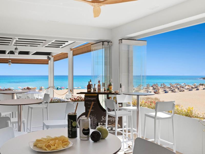 Restaurant ouvert avec vue sur la mer à la plage par temps ensoleillé.