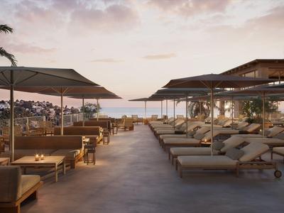 Moderner Poolbereich mit Sonnenliegen und Meerblick bei Sonnenuntergang in einem Luxushotel.