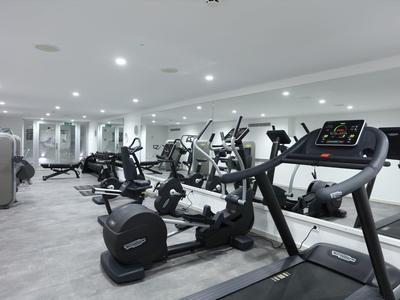 Modern gym with treadmills and exercise machines in a bright room.