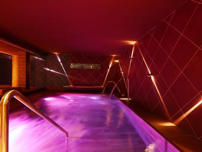 Indoor pool with mood purple lighting and modern design in a relaxing atmosphere