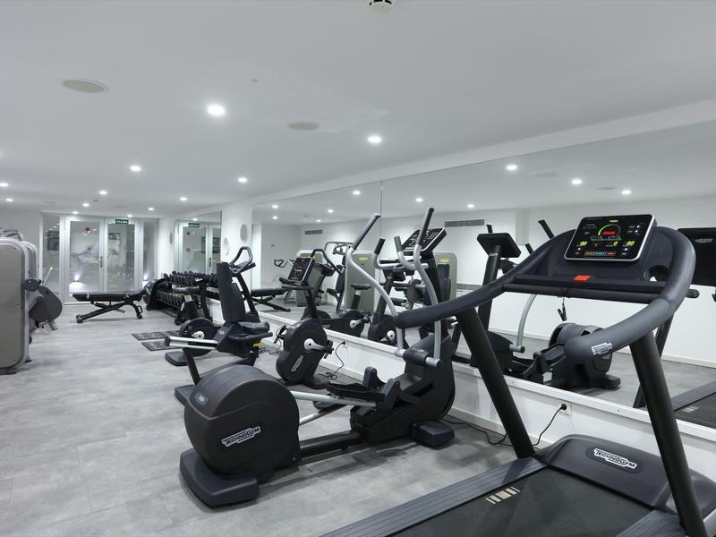 Modern gym with treadmills and exercise machines in a bright room.
