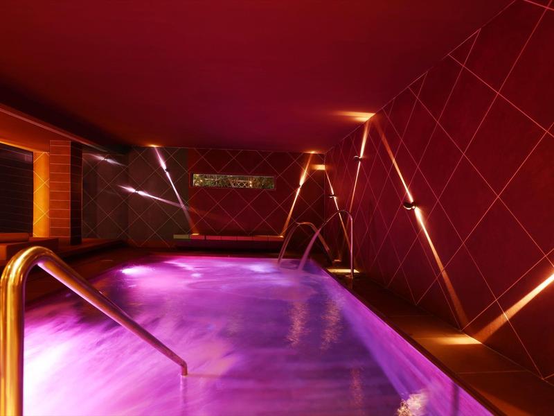 Indoor pool with mood purple lighting and modern design in a relaxing atmosphere