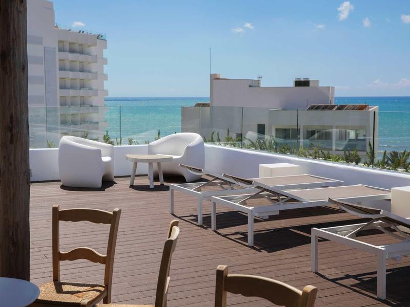 Taras słoneczny z leżakami i meblami do siedzenia z widokiem na morze pod czystym niebem.