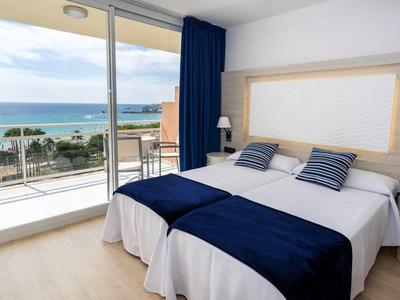 Elegantní dvoulůžkový pokoj s balkonem s výhledem na moře, modro-bílé zařízení.
