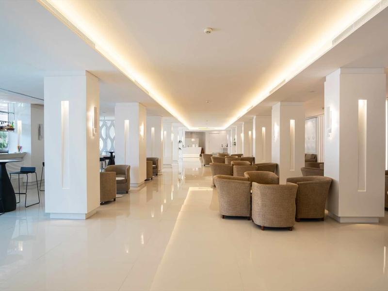 Světlý a moderní interiér hotelové haly s pohodlnými sedadly a elegantním barem.