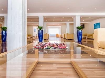 Bright hotel lobby with comfortable seating and decoration on a glass table.