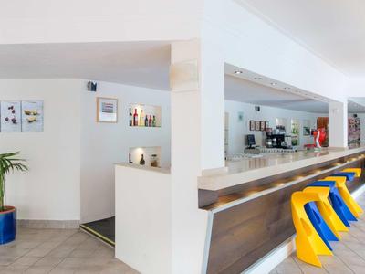 Moderne hotelbar met lichte inrichting en kleurrijke barkrukken