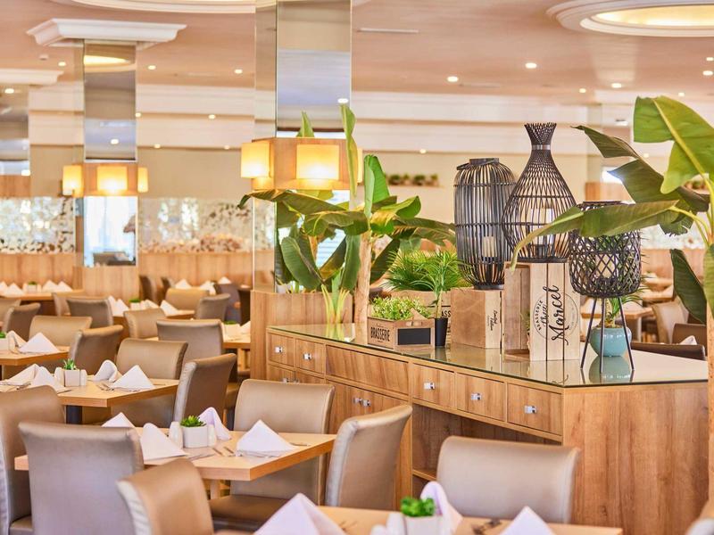 Moderní hotelová restaurace s elegantními sedačkami a zelenými rostlinami