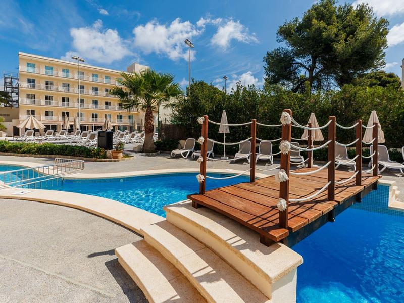 Hotel con piscina esterna, piccolo ponte in legno e lettini al sole