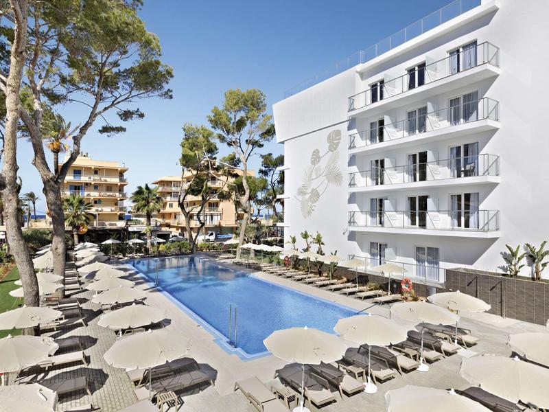 Piscina moderna de hotel con tumbonas y sombrillas en un área exterior soleada.