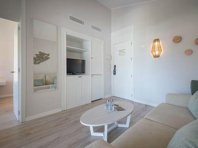 Bright hotel room with sofa, coffee table, and modern wall decor.
