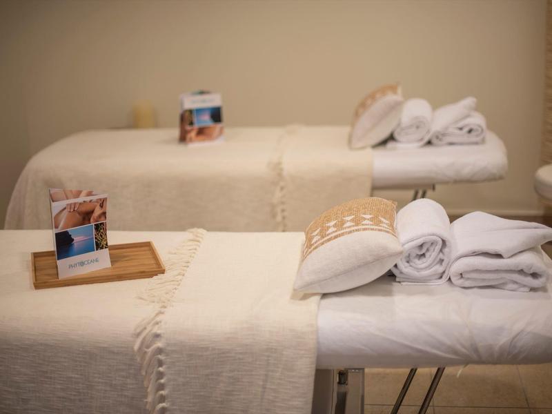 Two massage tables with white towels and warm lighting in a calm spa room.