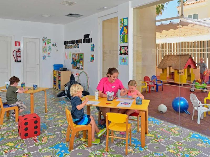 Colorful kids' playroom with small tables, chairs, and toys in the hotel.
