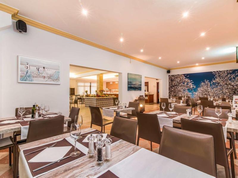 Cozy hotel restaurant area with set tables and modern decor.