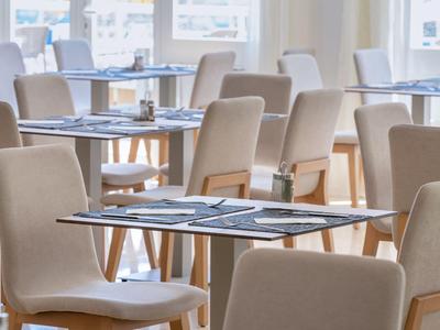 Sedute luminose e moderne in caffetteria o ristorante con tovagliette e luce naturale