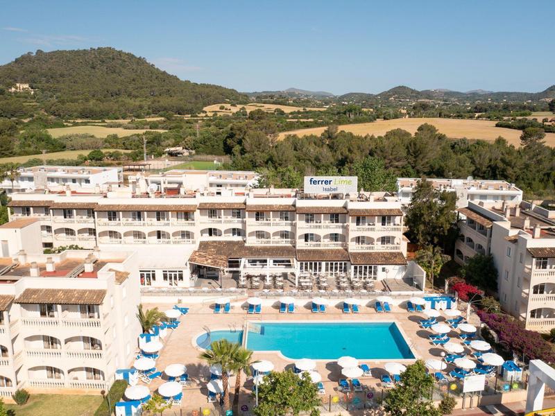 Grande hotel con più piani e una grande piscina in un ambiente rurale.