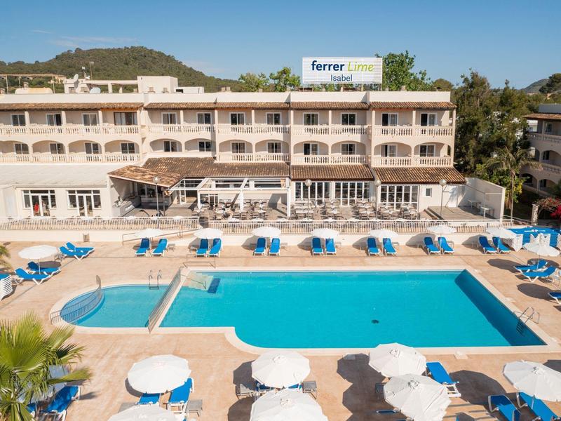 Grande hotel con piscina e ombrelloni davanti a una collina sotto un cielo sereno.