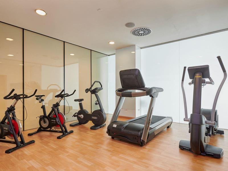 Modern gym with cardio machines and wooden floor in a hotel fitness room
