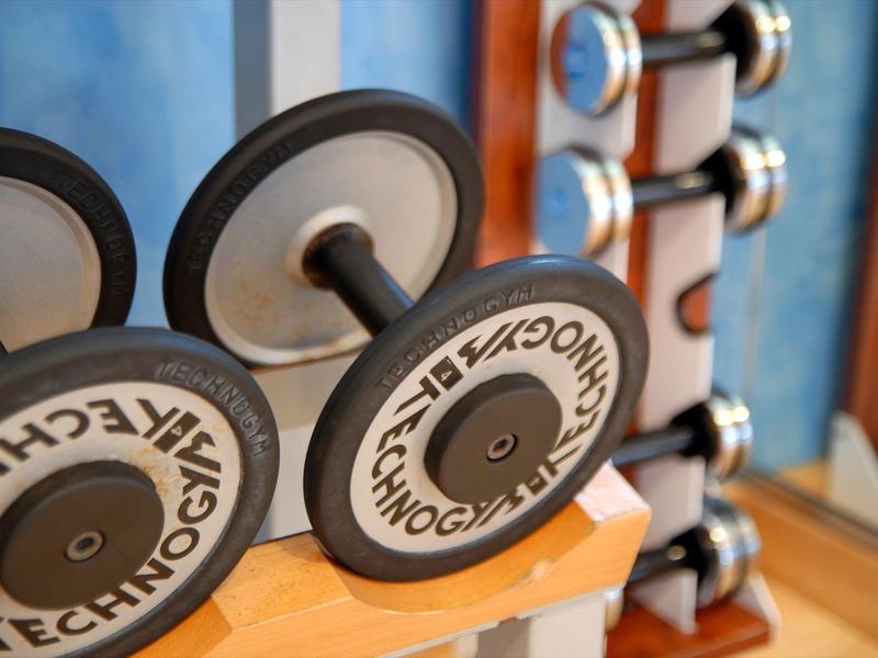Close-up of dumbbells on a rack in a gym or fitness area of a hotel.