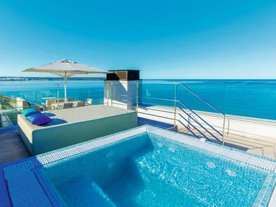 Terrazza panoramica di lusso con vasca idromassaggio, lettini e vista mare limpida