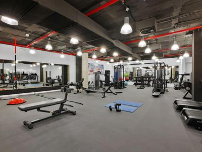 Grande palestra con vari attrezzi e specchi alle pareti