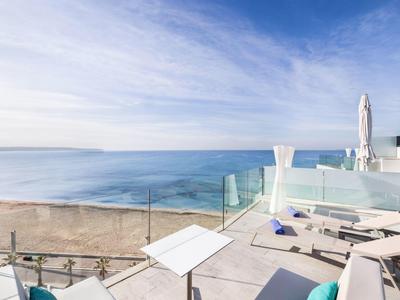 Terrazza moderna con ringhiera in vetro e vista mare su una spiaggia soleggiata