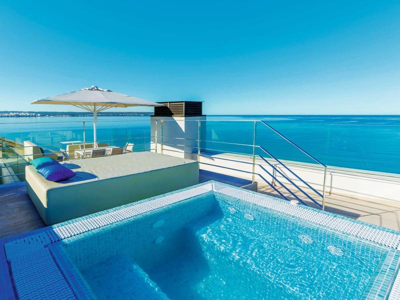 Area piscina di lusso con vasca idromassaggio e mobili lounge con vista sul mare.