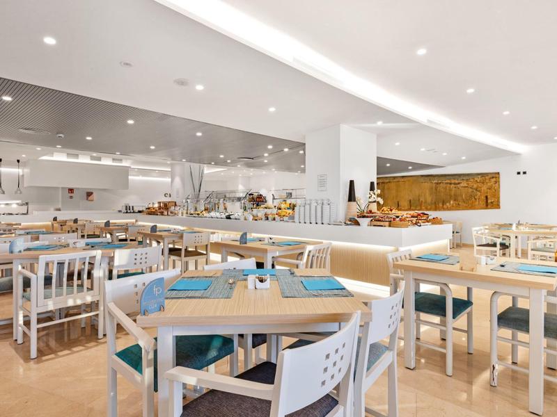 Sala da pranzo luminosa e moderna con mobili bianchi e accenti blu.