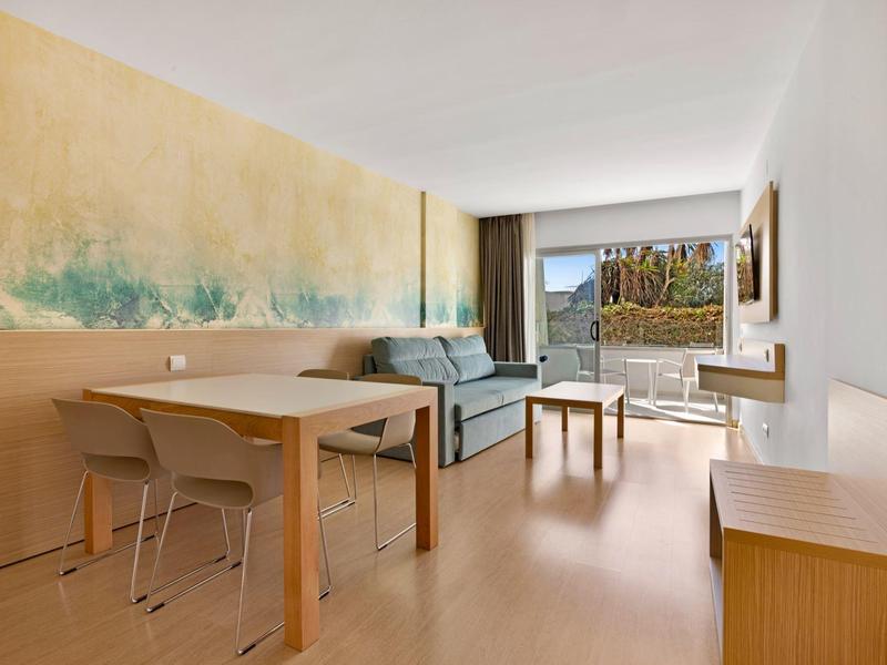 Soggiorno luminoso con tavolo da pranzo, divano e terrazza con vista mare.