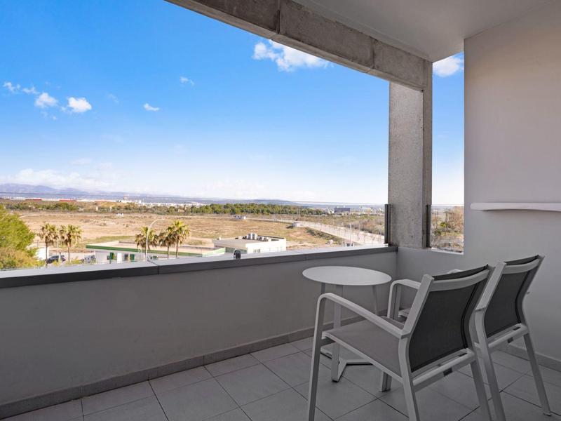 Balcone con due sedie e vista aperta sul paesaggio e il cielo.