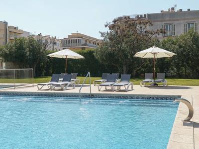 Bazén s lehátky a slunečníky v městském prostředí