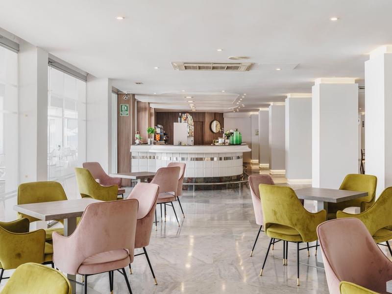 Area lounge dell'hotel luminosa con sedie moderne e bar elegante